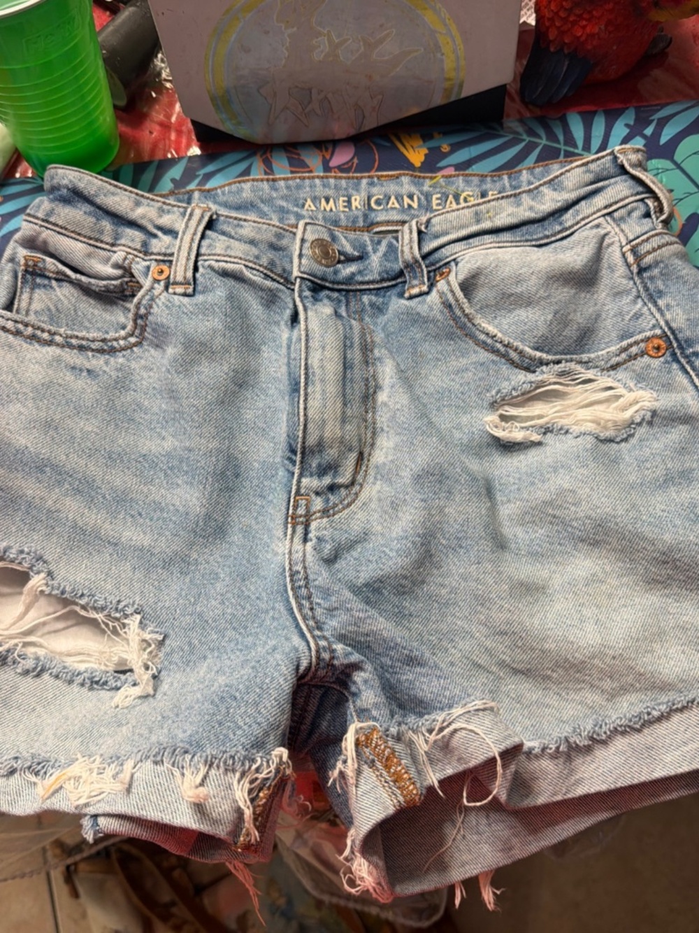 American Eagle light blue denim shorts with a distressed, ripped finish and fray